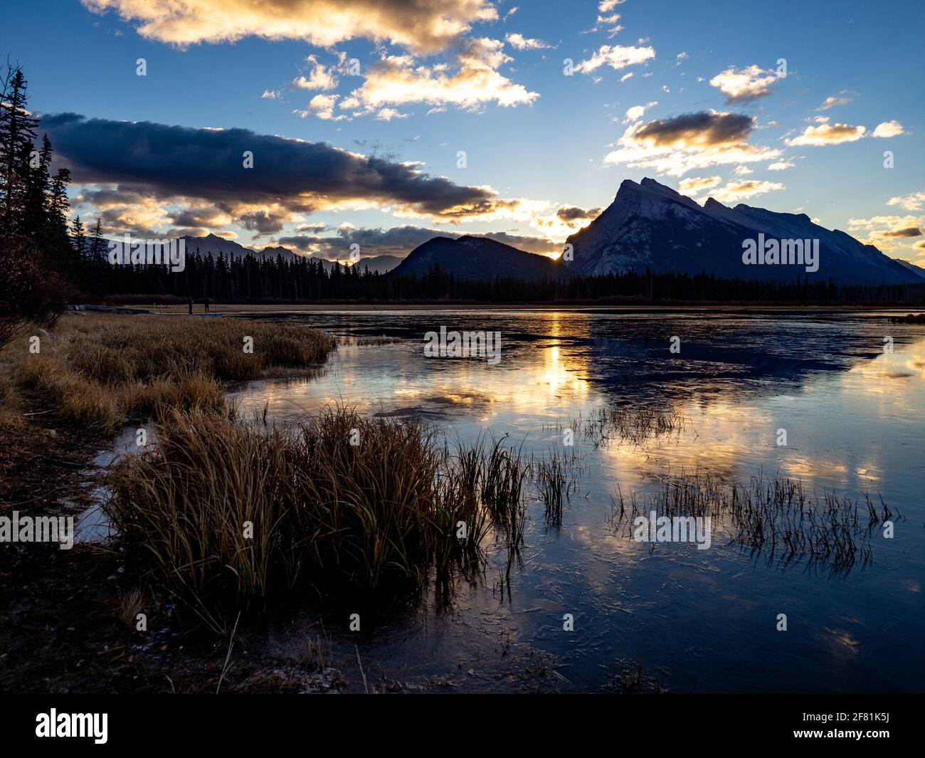 Calm lake in the morning with light behind the mountains in summer Stock Photo