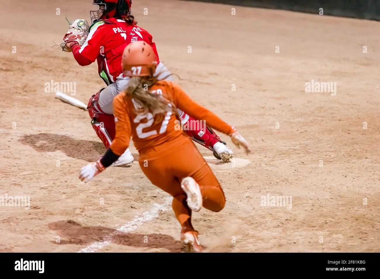 A Texas Longhorn Player is Sliding Into Home Plate Scoring A Run Stock Photo