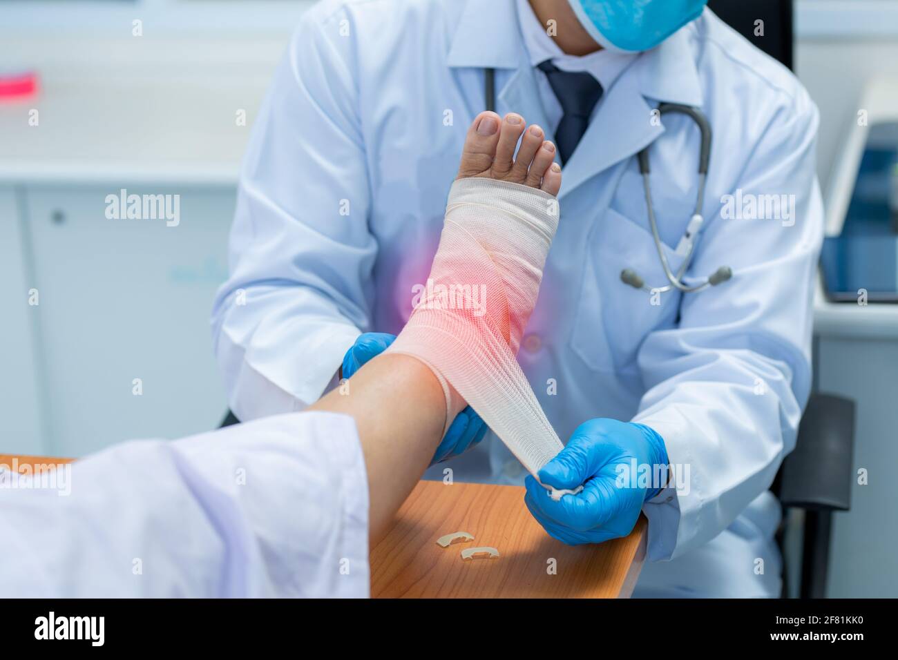 Close-up hand of orthopedic doctor wear medical gloves  Of Doctor Hand Tying Bandage On The Leg Of Patient In Clinic, osteophytes and heel, inflammati Stock Photo