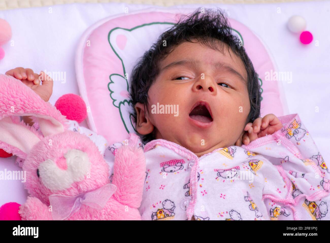 One month's old cute baby girl yawning in her 1st photo session celebrating 1 month's birthday. time for a dreamy nap. Stock Photo