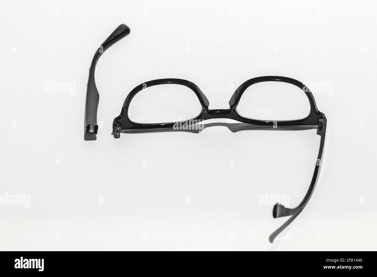 The glasses are damaged, the parts are separated. Focus on the legs of the glasses that have come off. Stock Photo