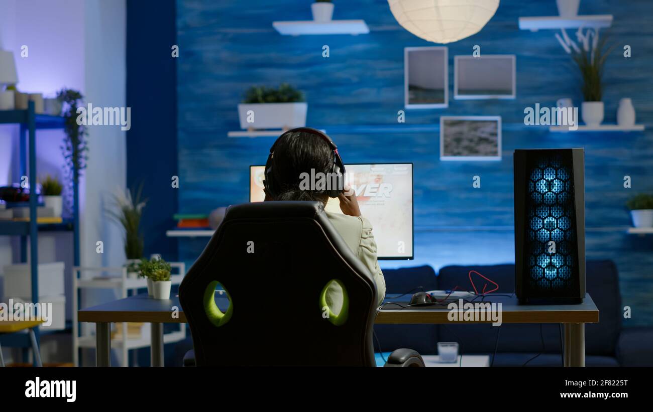 Back shot of pro gamer playing online shooter game on computer using  wireless controller. Competitive player man winning videogame tournament  use professional equipment at home gamming studio Stock Photo - Alamy