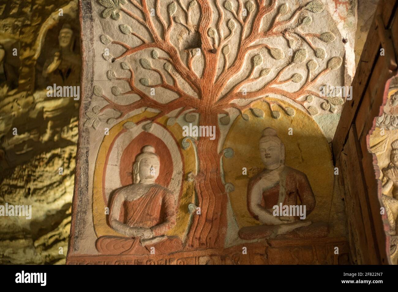 Bodhi tree and two Buddha sitting statues at Yungang Grottoes, early Buddhist cave temples, Unesco World Heritage Site, Shanxi, China. Stock Photo