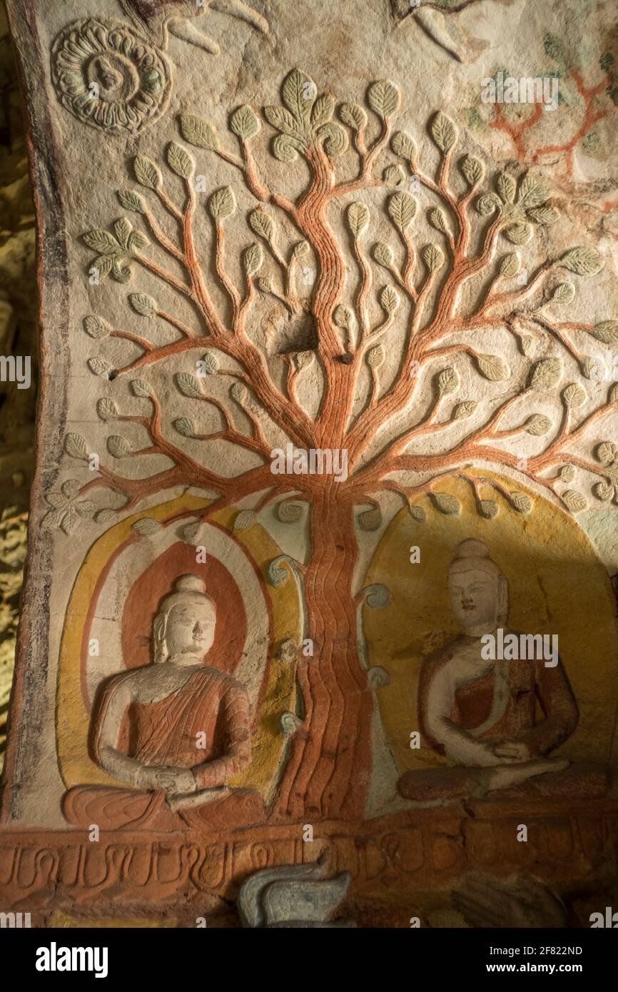 Bodhi tree and two Buddha sitting statues at Yungang Grottoes, early Buddhist cave temples, Unesco World Heritage Site, Shanxi, China. Stock Photo