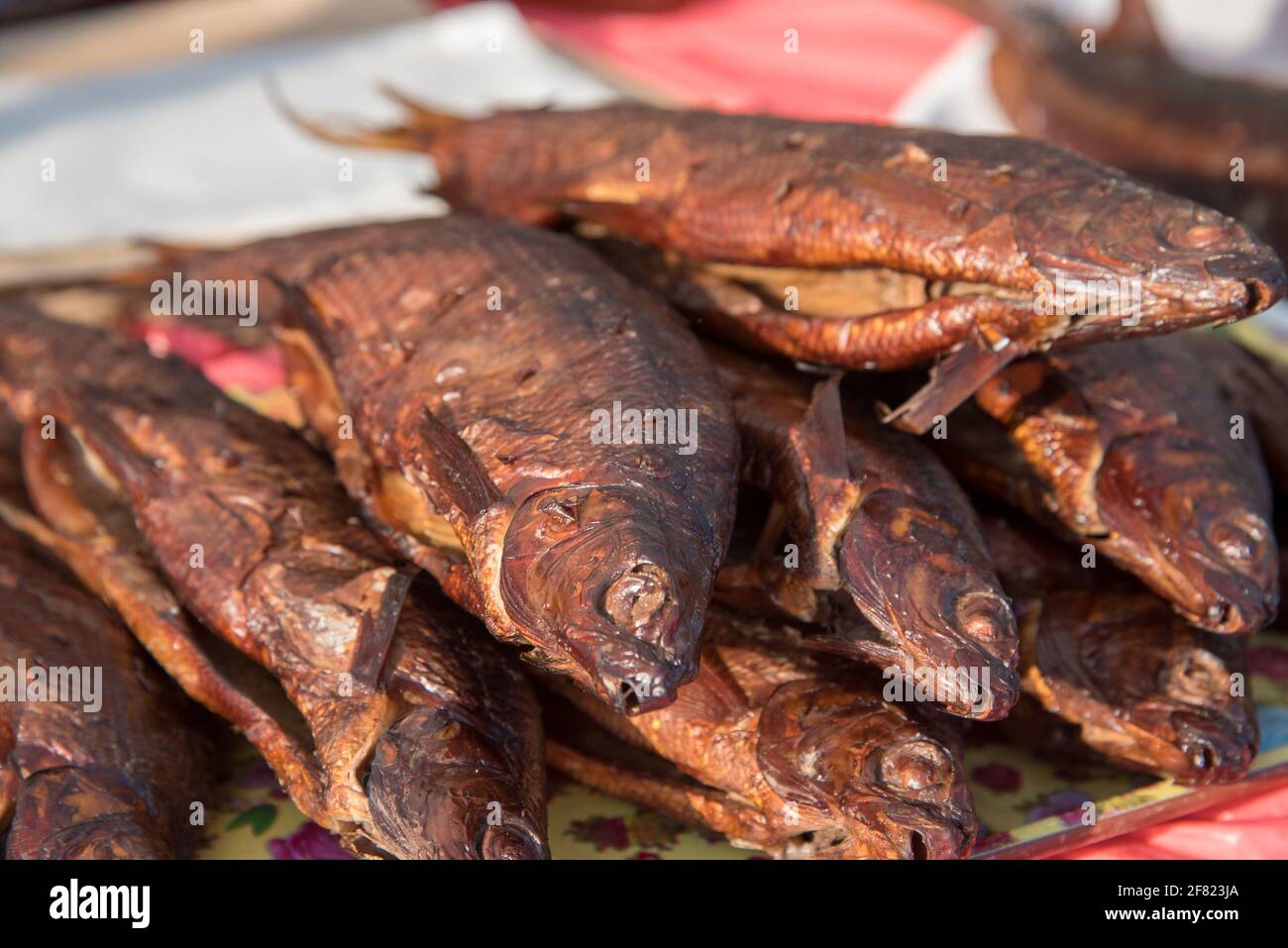 Smoked and dried cured fish are sold on the market counter on the