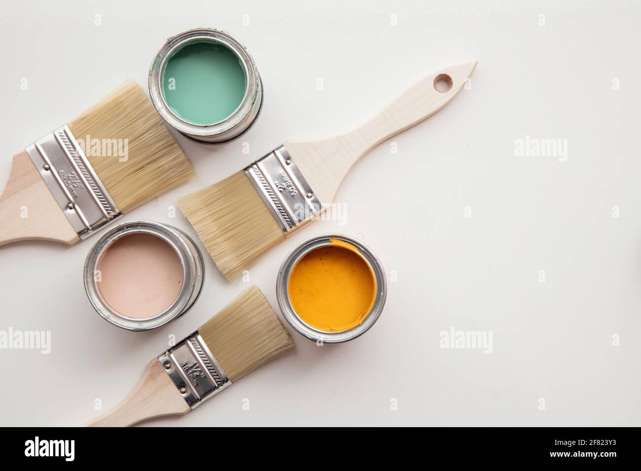 Overhead view of a DIY paint brush with colorful sample paint pots Stock Photo