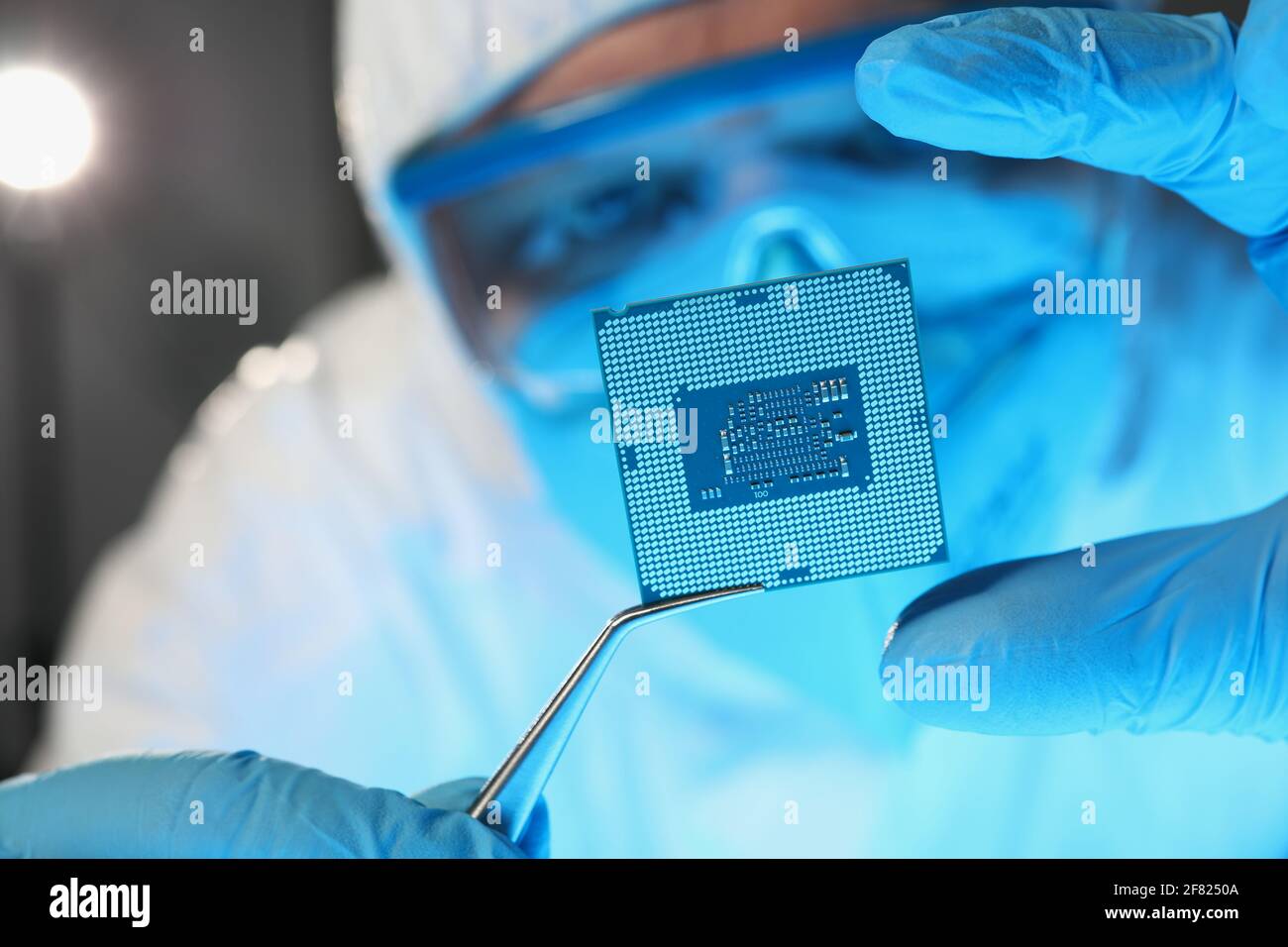 Scientist developer in protective suit holds microcircuit Stock Photo