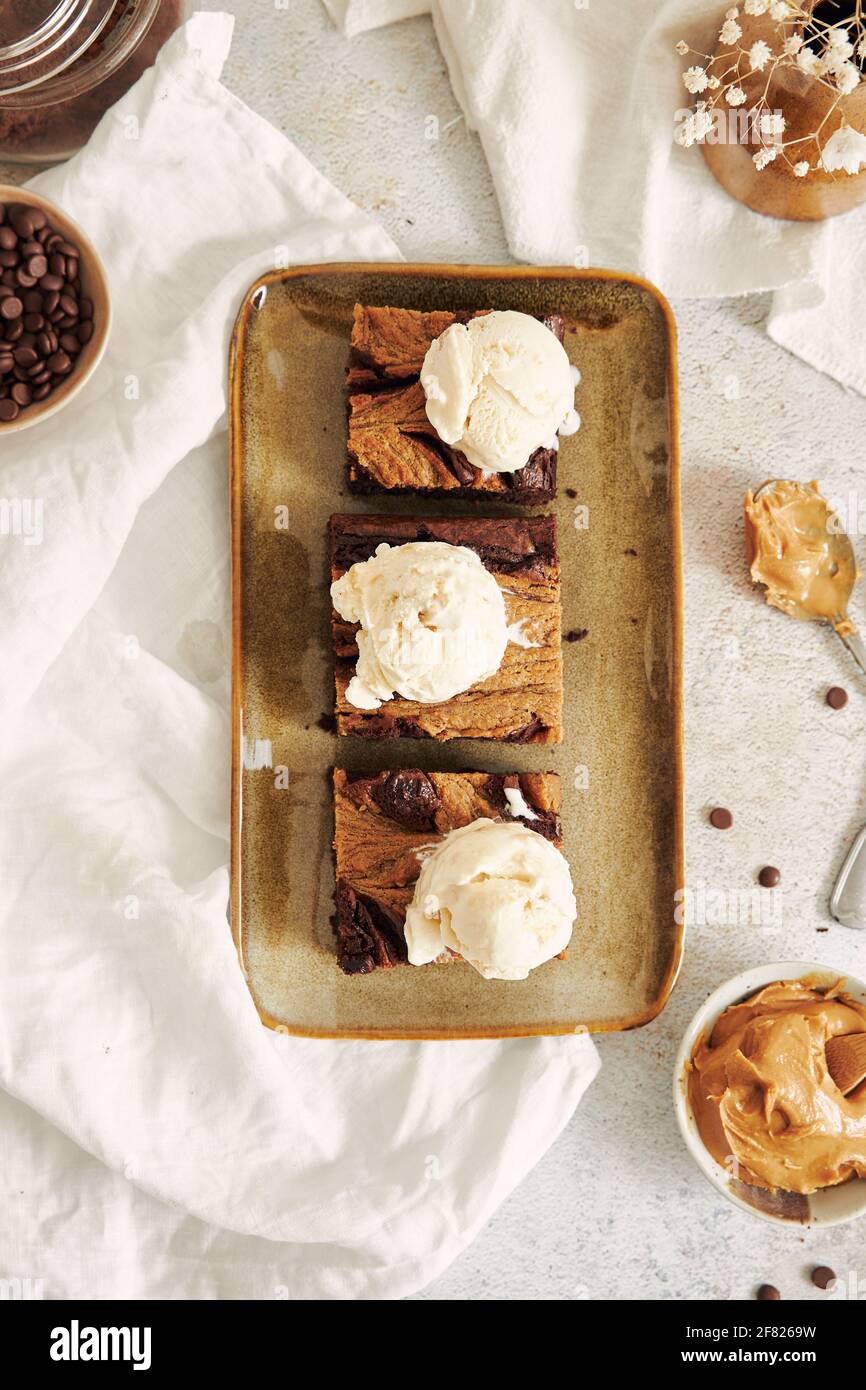 A vertical shot of delicious peanut butter swirl brownies with ice ...