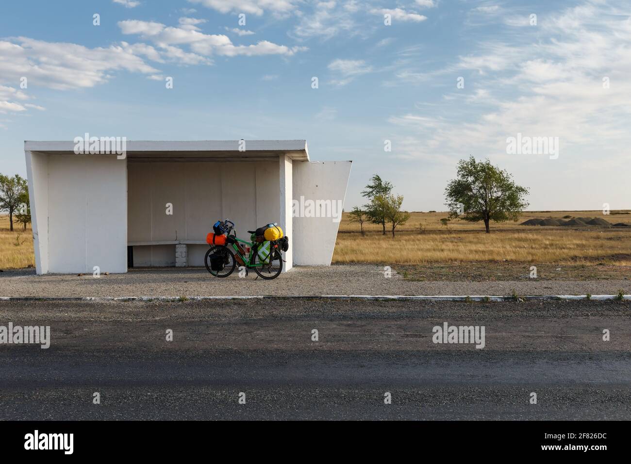 tourist bike stands at a bus stop in Kazakhstan. Bicycle with heavy bags. Cycling around the world. Stock Photo