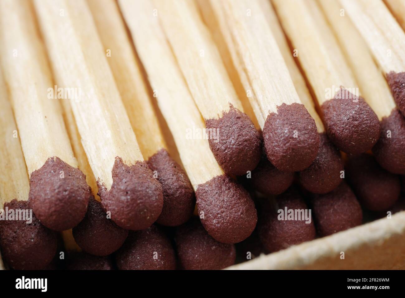 macro of wooden matchsticks in open matchbox, closeup of brown match heads Stock Photo