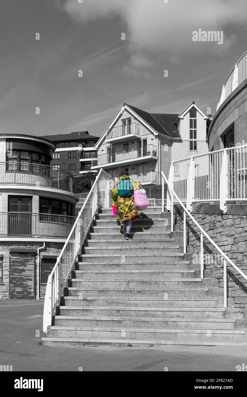 Woman climbing steps to seafront apartments at Boscombe, Bournemouth, Dorset UK in April Stock Photo