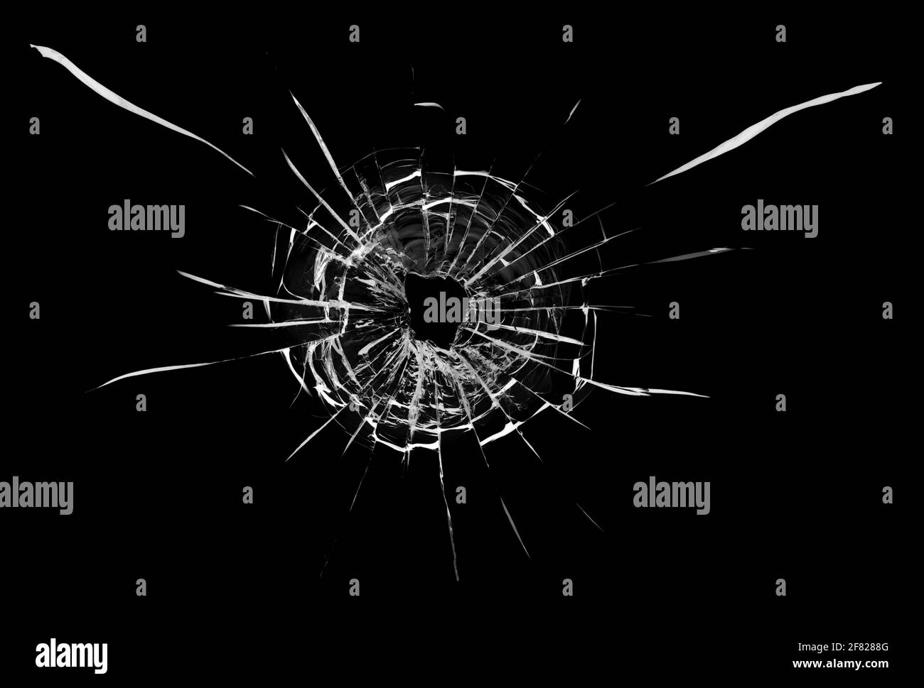 Bullet hole in the glass. Isolated on a black background. Stock Photo