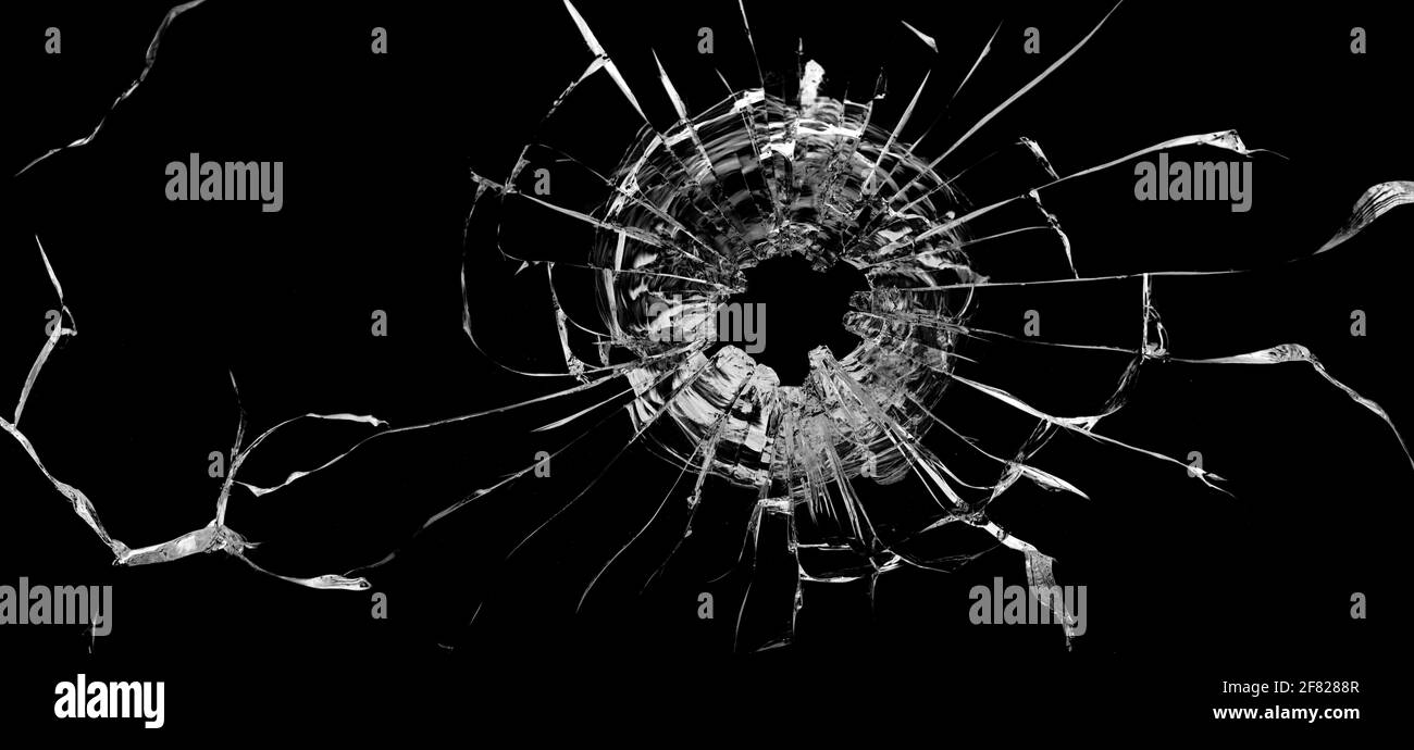 Bullet hole in the glass. Isolated on a black background. Stock Photo