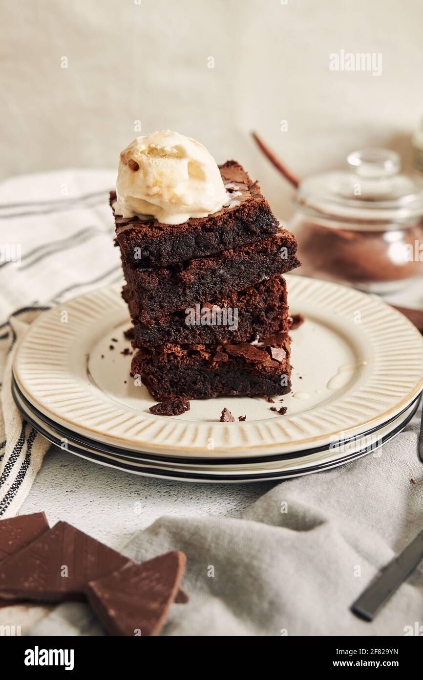 A vertical shot of a delicious brownie with ice cream on a white plate ...