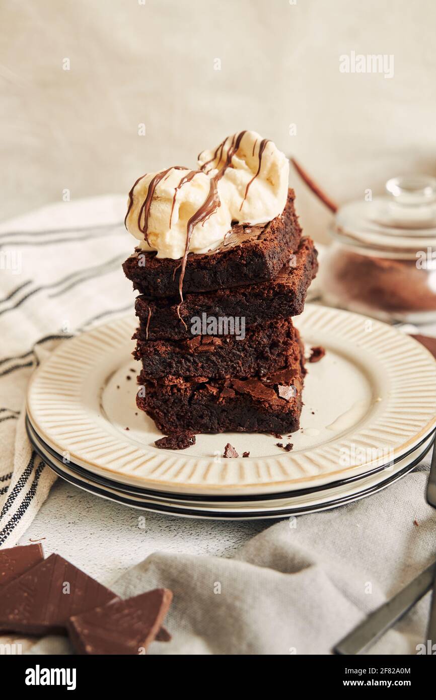 A vertical shot of a delicious brownie with ice cream on a white plate ...