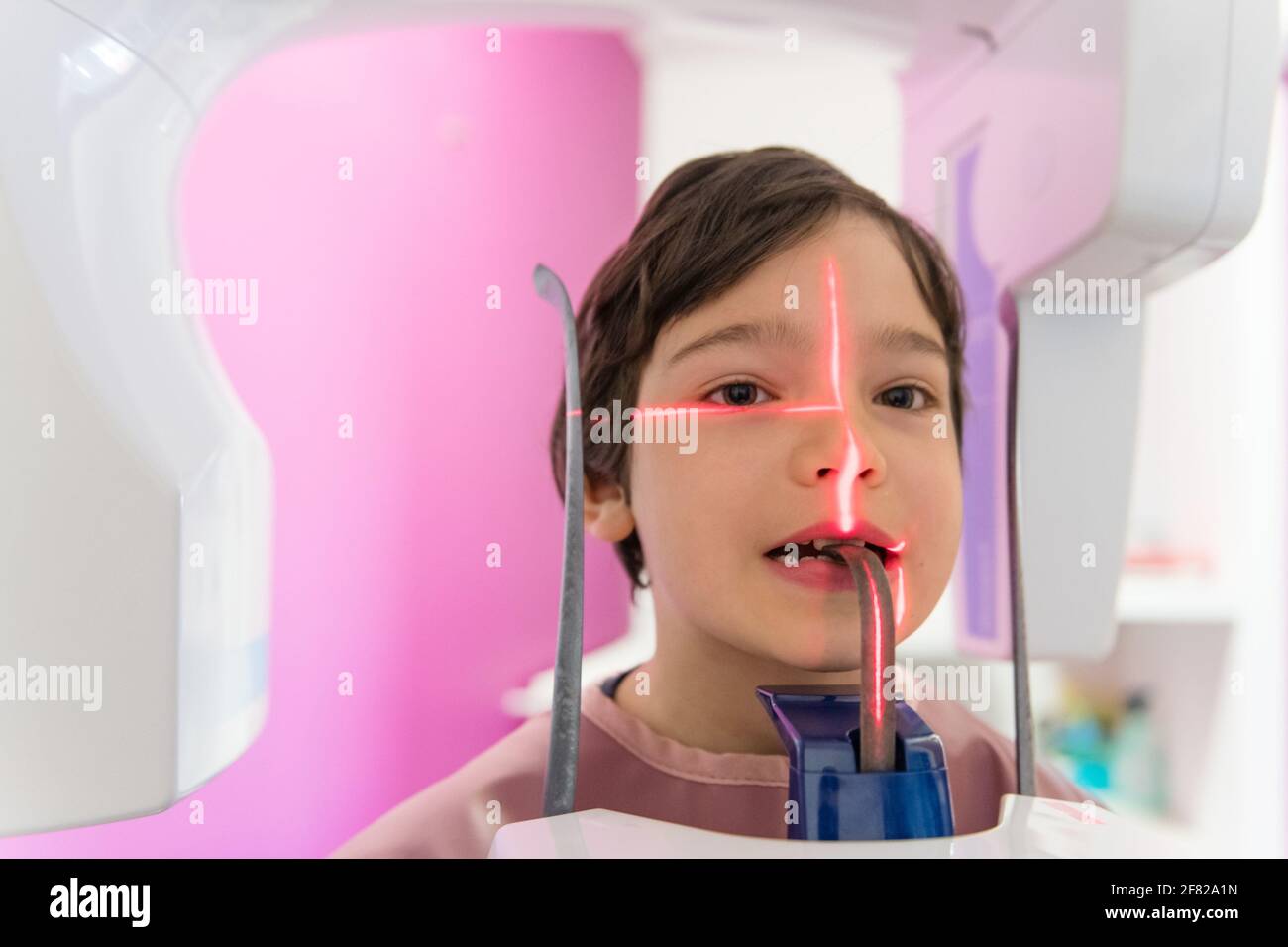 Young boy in protective wear making panoramic x-ray shot of a tooth in the dental office Stock Photo