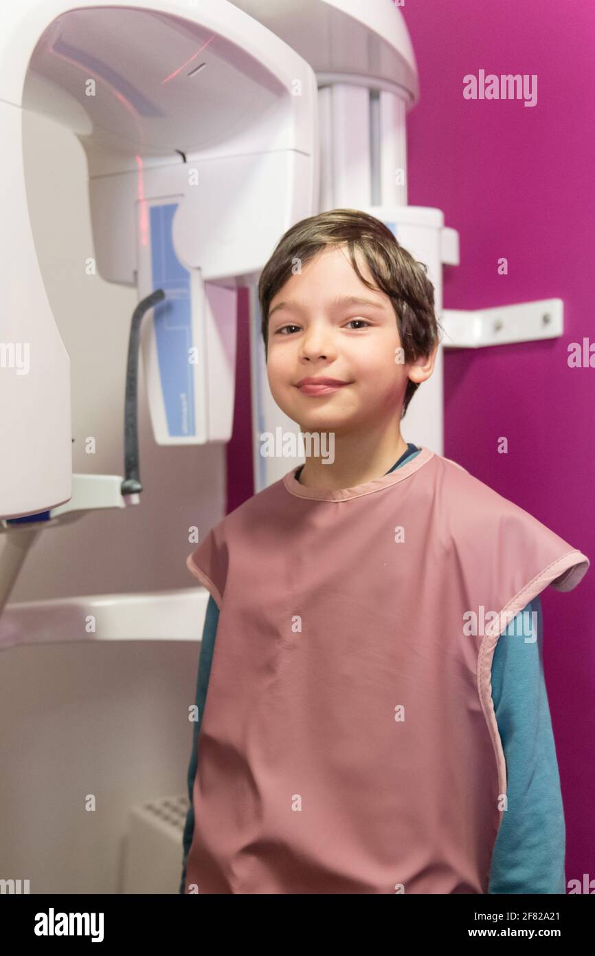 Young boy in protective wear with x-ray machine in the dental office Stock Photo