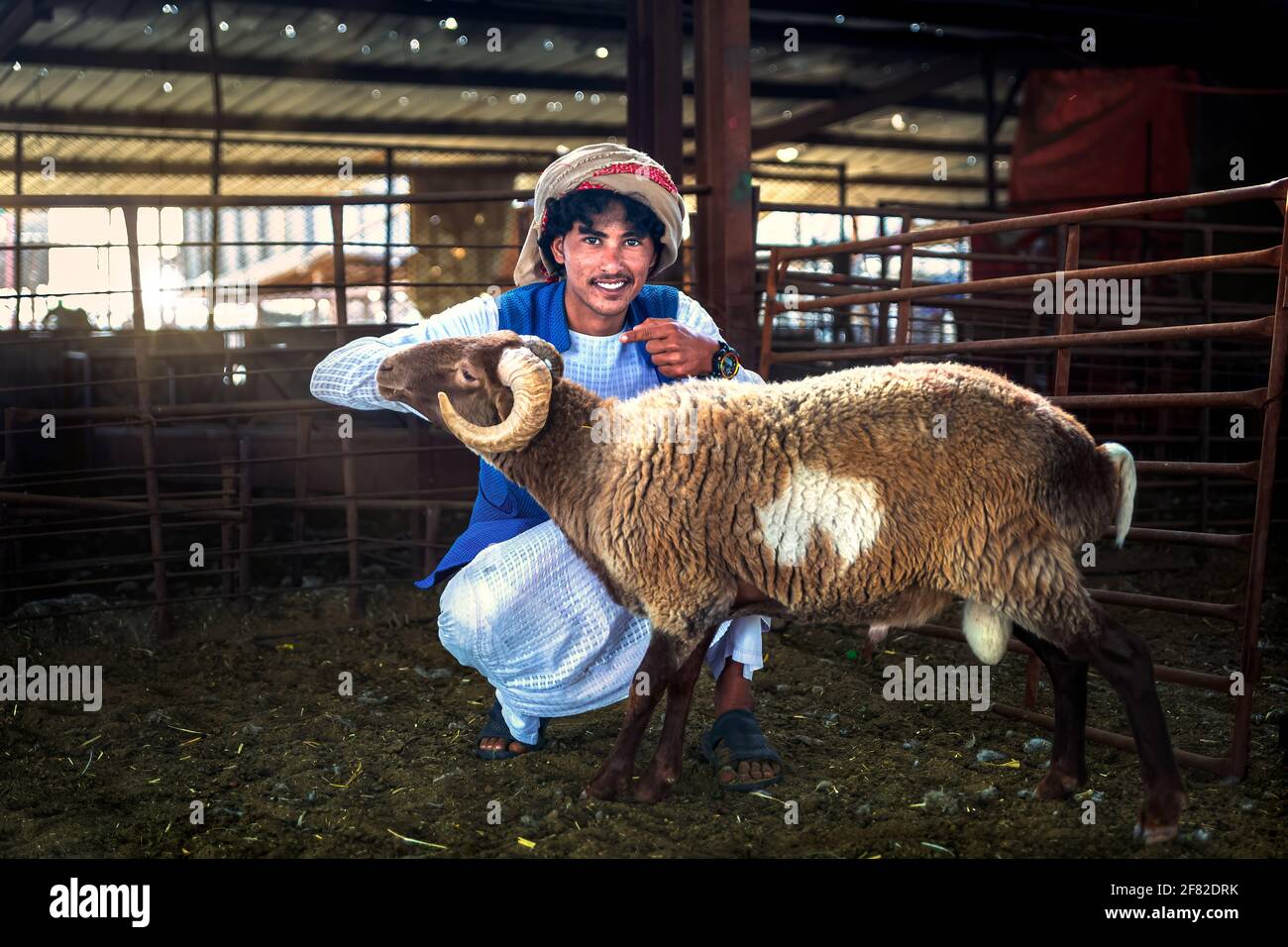 Dammam, Saudi Arabia - 02-April-2021. Young adult man with his goat on their cattle farm. Stock Photo