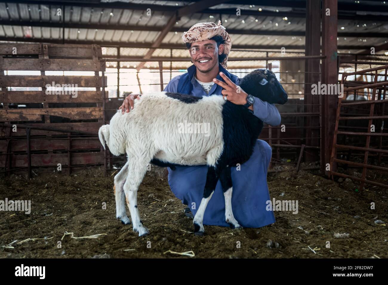 Dammam, Saudi Arabia - 02-April-2021. Young adult man with his goat on their cattle farm. Stock Photo