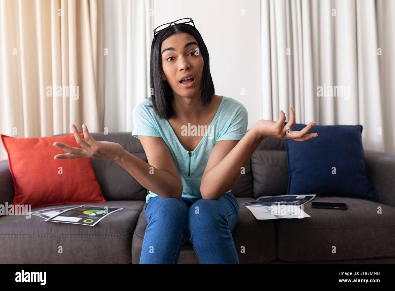 Mixed race gender fluid man working at home making video call, talking and gesturing Stock Photo