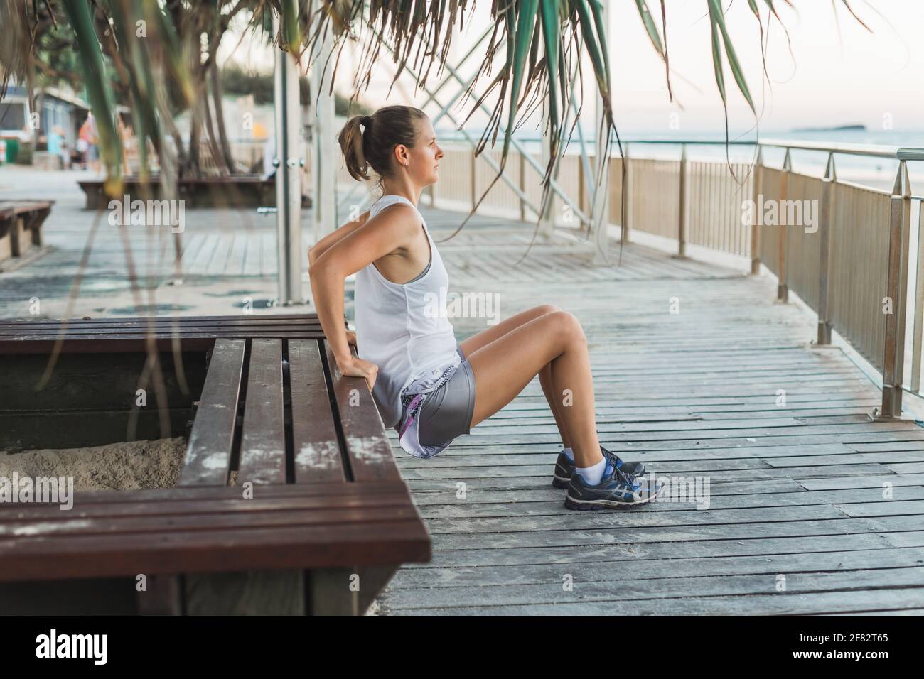 Young beautiful sportive woman doing exercises on beach Stock Photo