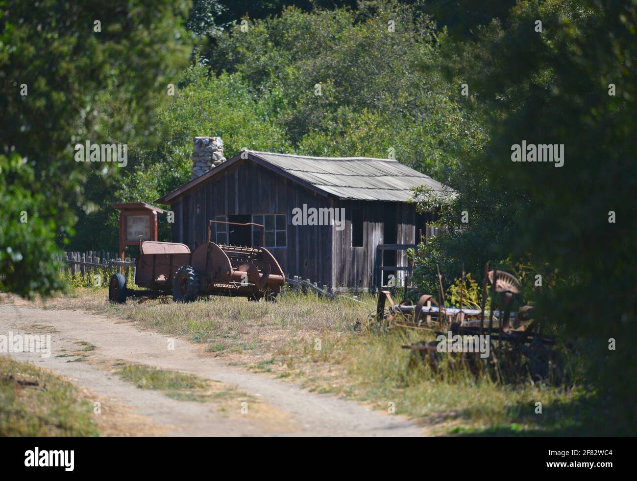 Landscape with an old abandoned barn and agriculture equipment on the ...