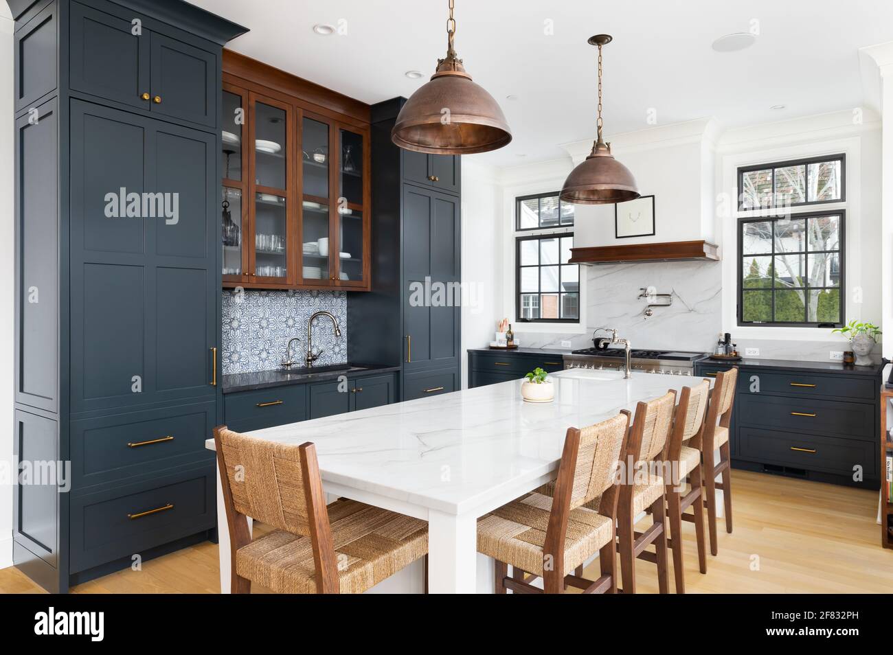A luxurious kitchen with blue cabinets bronze dome light fixtures