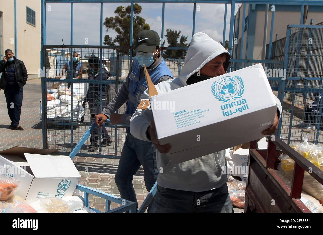 Rafah, Gaza. 11th Apr, 2021. Palestinians receive aid distributed by United Nations Relief and Works Agency (UNRWA) at the Rafah refugee camp in the southern Gaza Strip on Sunday, April 11, 2021. The United States said it was restoring assistance to the Palestinians, and would contribute $150 million to the UN agency, plus $75 million in economic and development assistance for the West Bank and Gaza as well as $10 million for peacebuilding efforts. Photo by Ismael Mohamad/UPI Credit: UPI/Alamy Live News Stock Photo