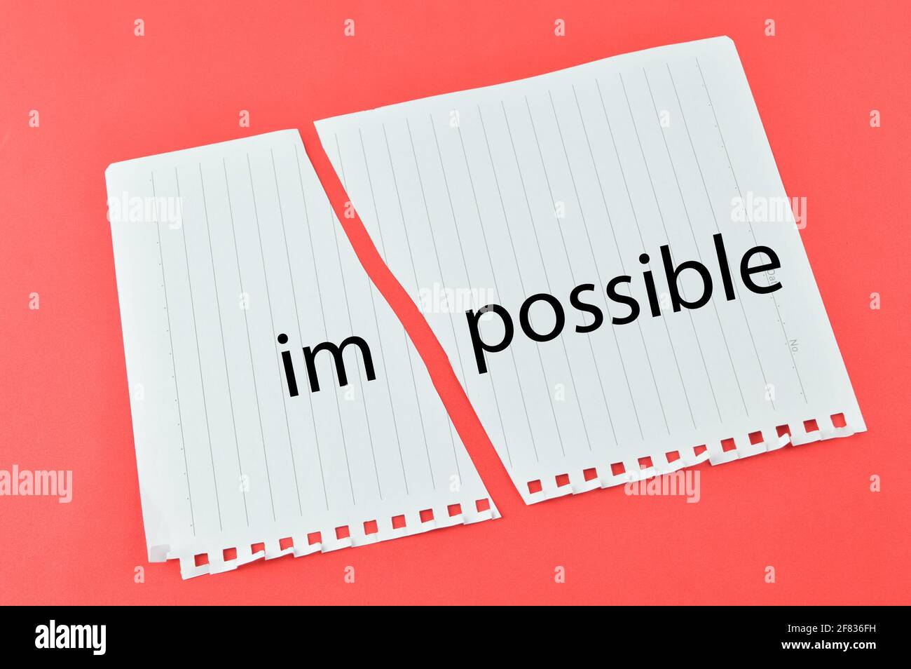 Torn paper written with text IMPOSSIBLE over red background. Stock Photo
