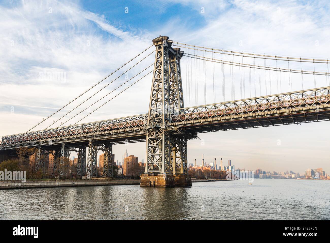 view of a suspension bridge from a boat on a sunset on a nice summer day Stock Photo