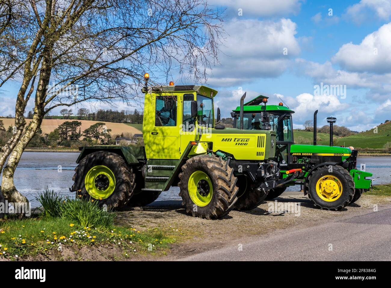 Timoleague, West Cork, Ireland. 11th Apr, 2021. Two vintage tractors enjoy the sun in and around the West Cork village of Timoleague on a beautiful sunny day. The tractors, a 1990 Mercedes MB Trac 1100 and a 1992 John Deere 2850 are owned by farmers David Deasy and Paudie O'Leary, who both live in Timoleague. Credit: AG News/Alamy Live News Stock Photo