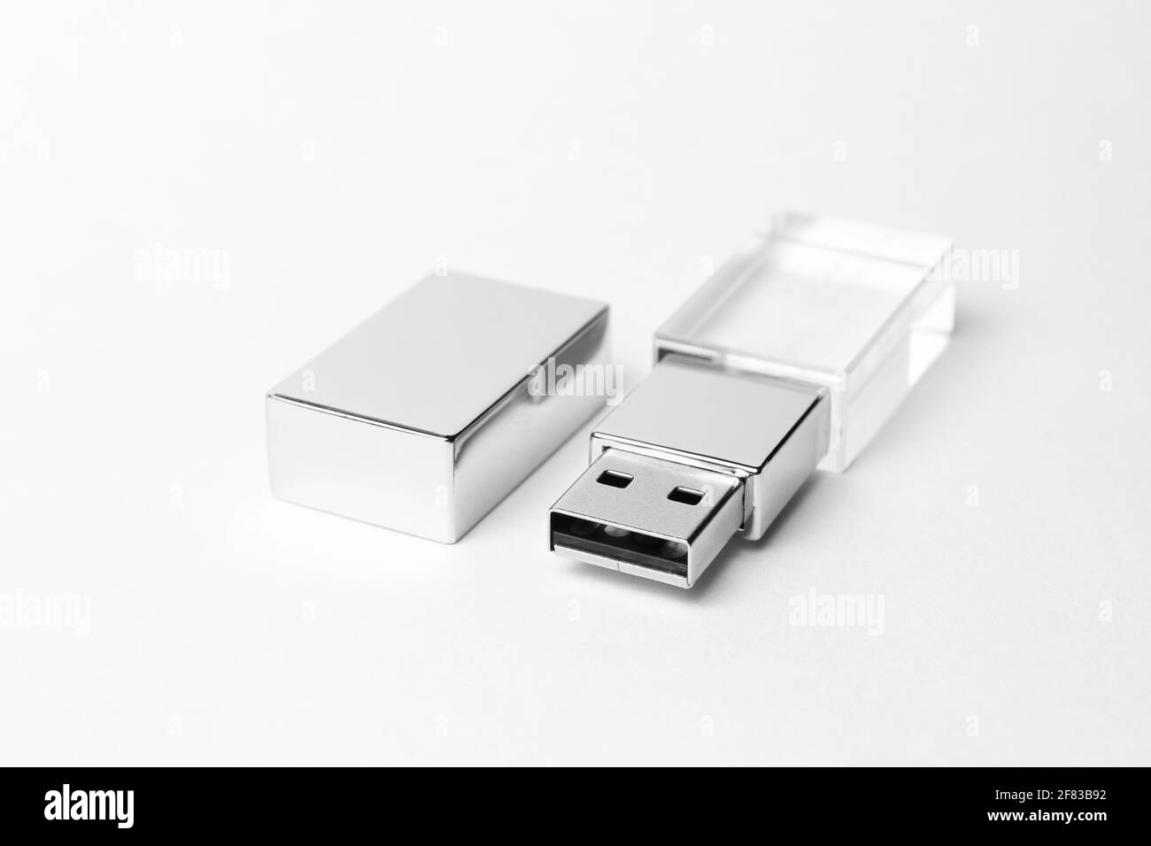 Glass USB stick with a metal cap on grey background. Close-up photo. Copy space. A high resolution. Stock Photo