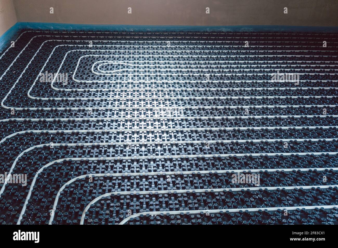 Pipes for underfloor heating ready to be covered with grout Stock Photo