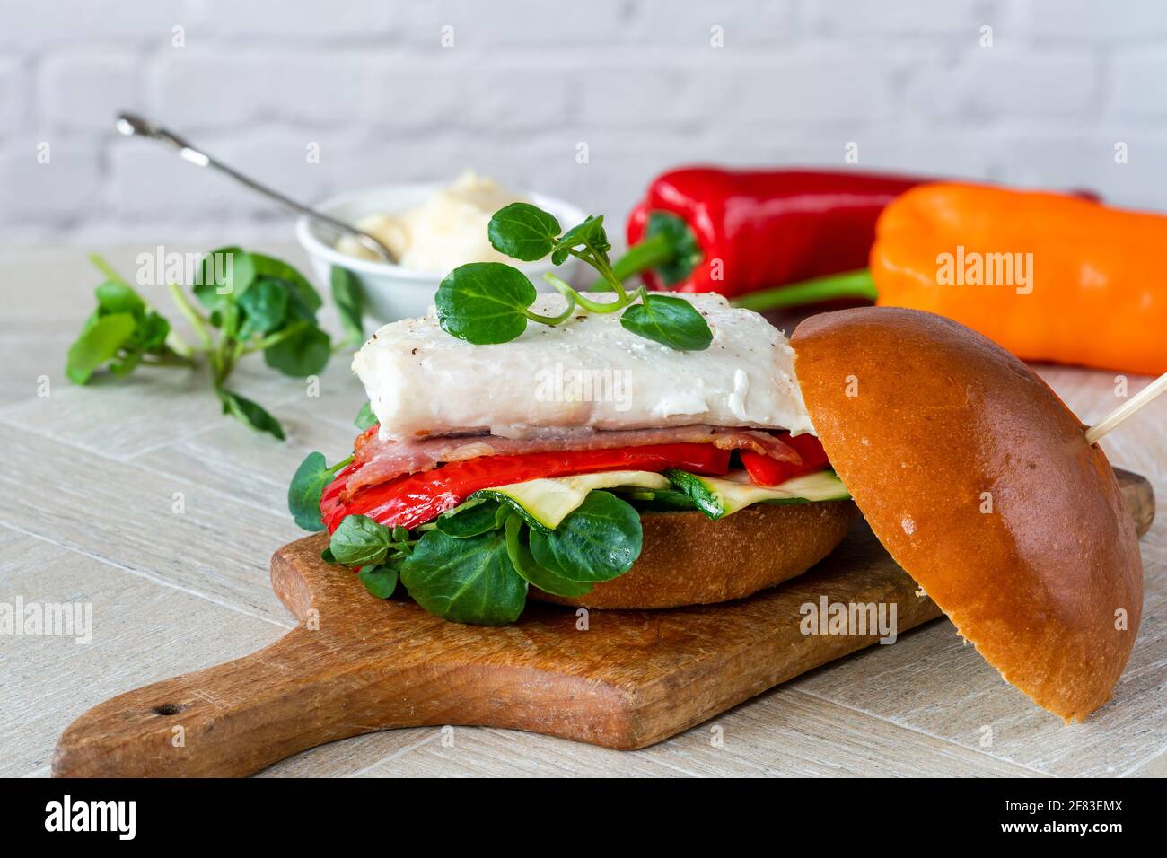 Grilled halibut sandwich in brioche bun with bacon, red romano pepper