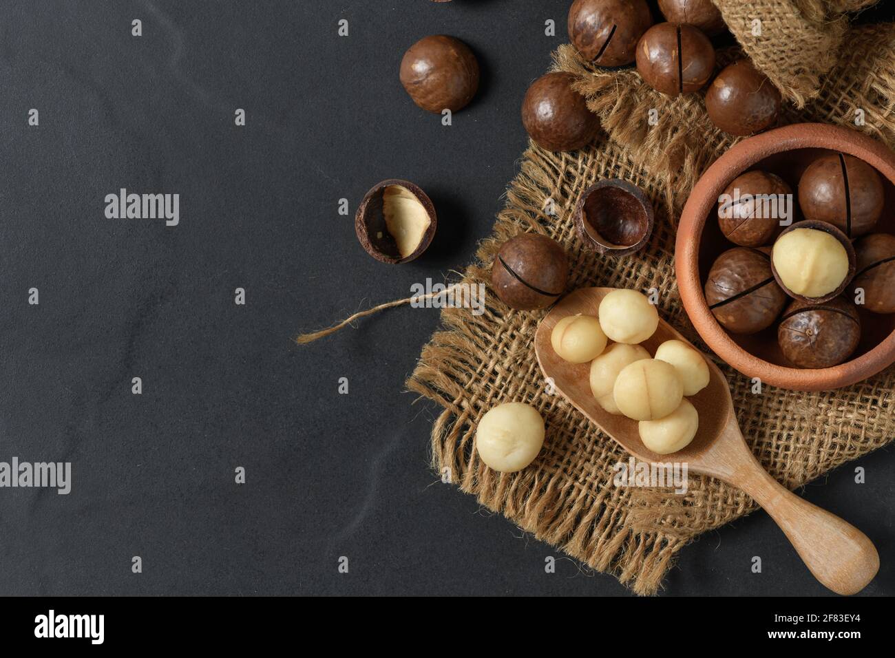 Dry Roasted Macadamia Nut in wood spoon and on black background