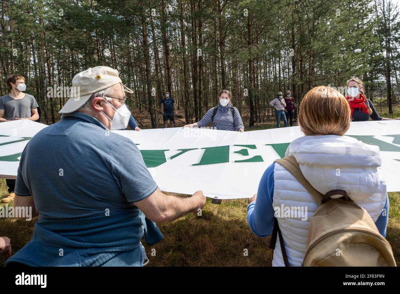 Schleife, Germany. 11th Apr, 2021. A banner with the inscription 'UNVERKÄUFLICH www.kein-tagebau.de' is held in the forest near Schleife by participants of the protest action. The protest action 'Unverkäuflich' of the environmental network Grüne Liga in Schleife near the opencast mine Nochten in the district of Görlitz is directed against the threatening dredging by LEAG (Lausitz Energie Bergbau AG). Credit: Daniel Schäfer/dpa-Zentralbild/dpa/Alamy Live News Stock Photo