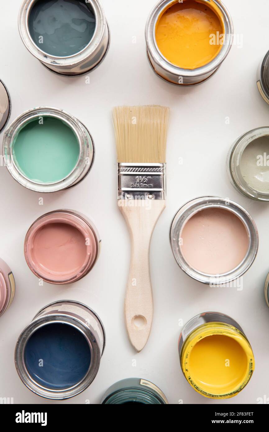 Overhead view of a DIY paint brush with colorful sample paint pots Stock Photo