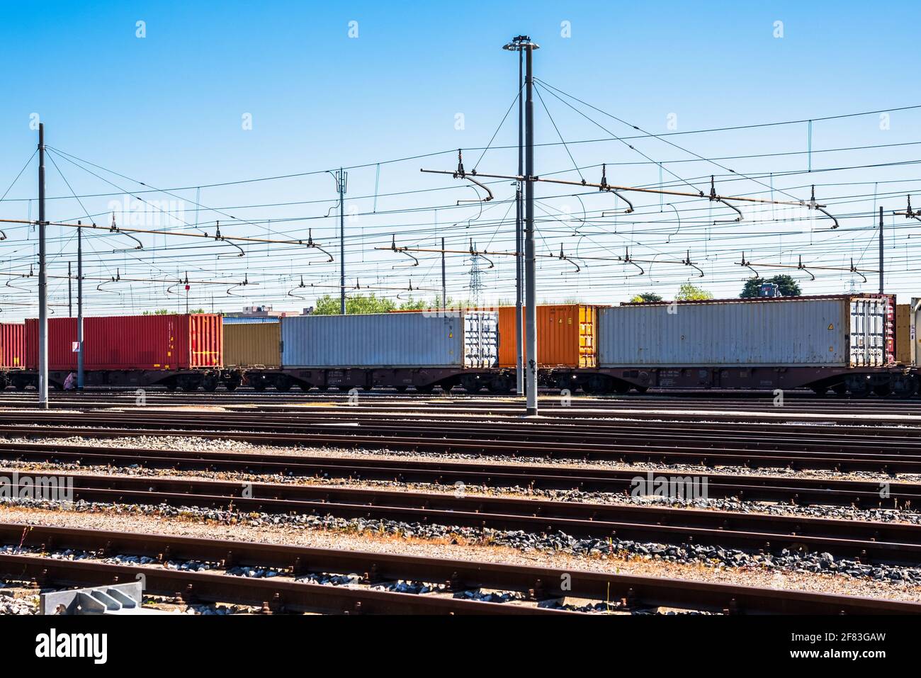 Cargo trains loaded with colourful containers in a freight terminal Stock Photo