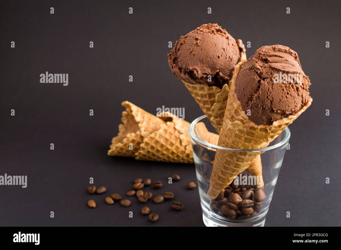 Close-up on chocolate ice cream in a waffle cone on the black ...