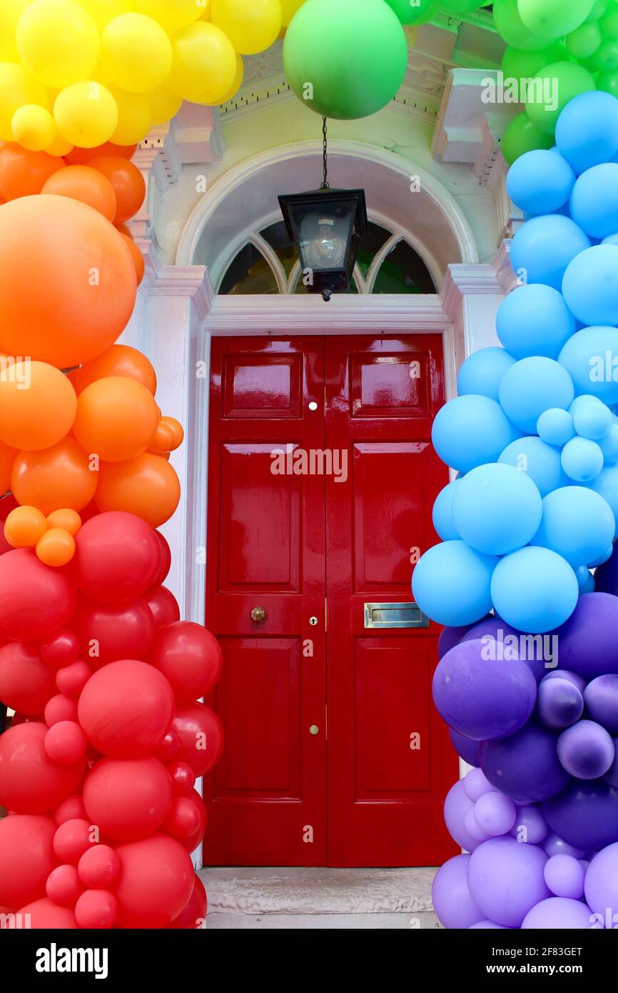 As lockdown restrictions end on May 12th 2021 a local business adorns its front door with colourful baloons to welcome back customers. Stock Photo