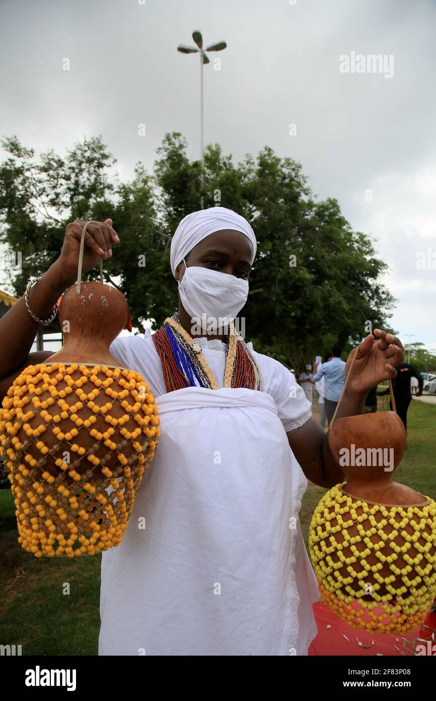 salvador, bahia, brazil - january 6, 2021: adept of candomble holds the xequere, also known as abe e agbe, a percussion musical instrument made of gou Stock Photo