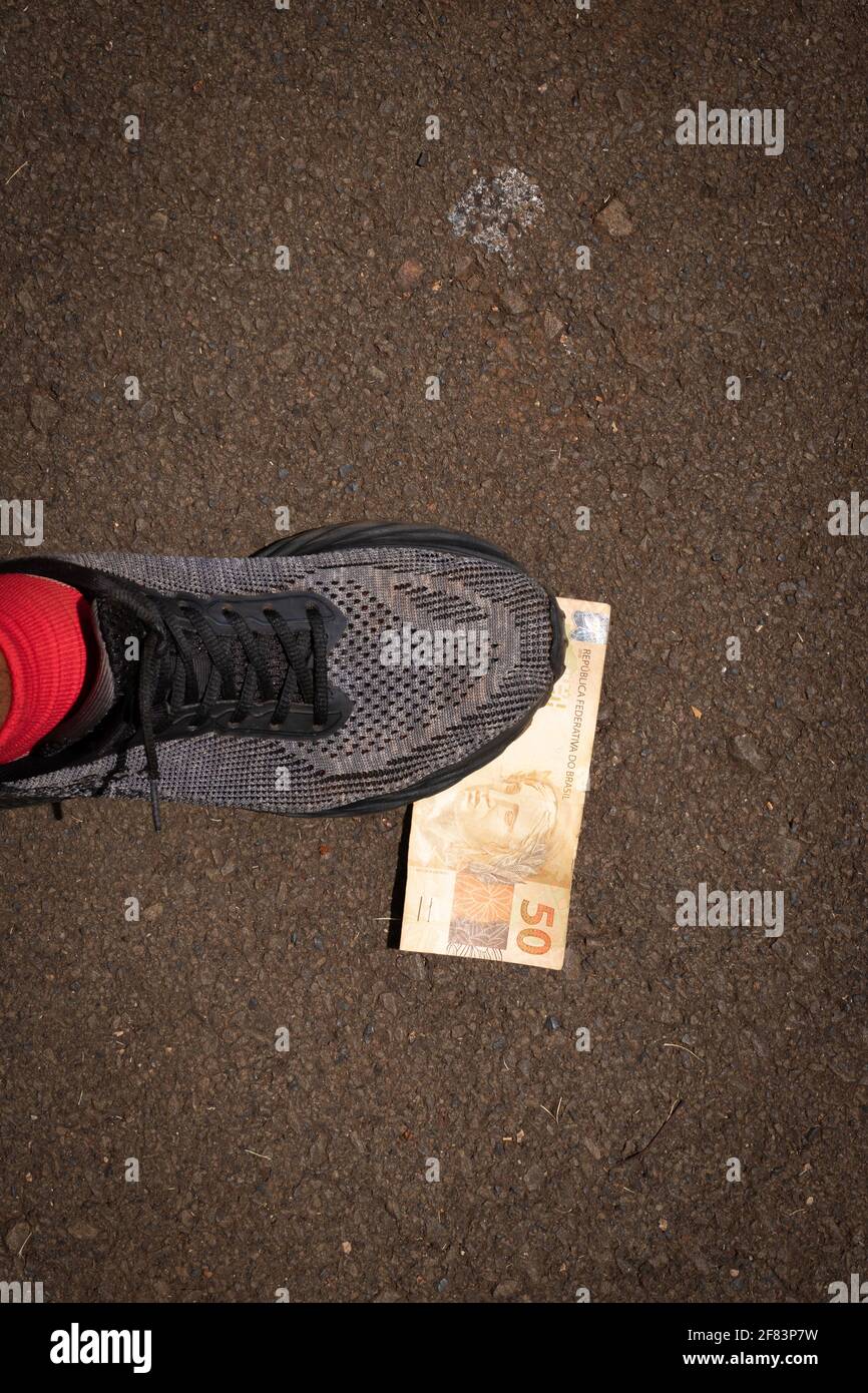 Stepping on Brazilian money. Concept image of Brazilian economy. Stock Photo