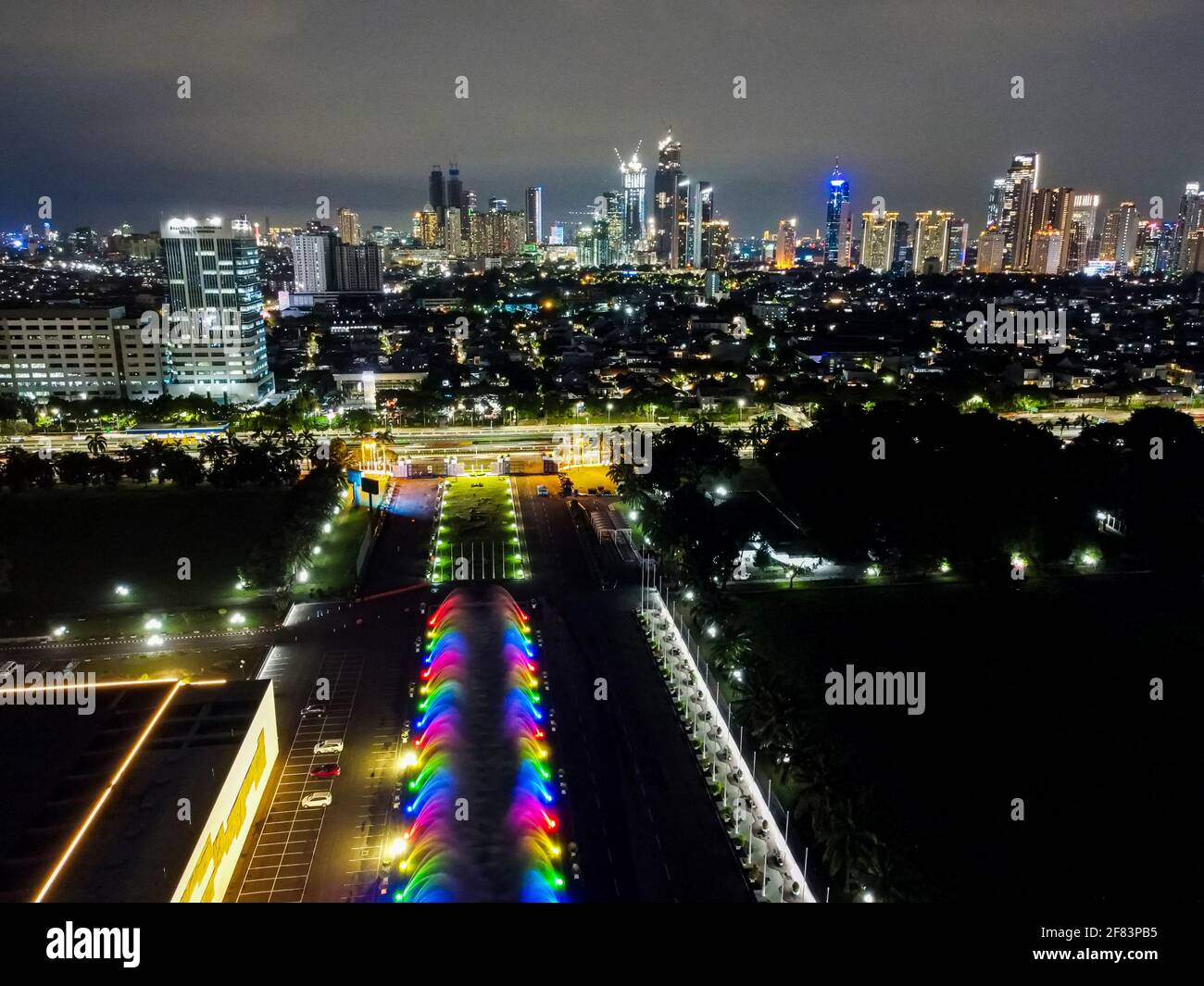 Aerial drone view of the Indonesia Parliament Complex, which is also known as the DPR/MPR building with Jakarta cityscape at sunset with noise cloud. Stock Photo