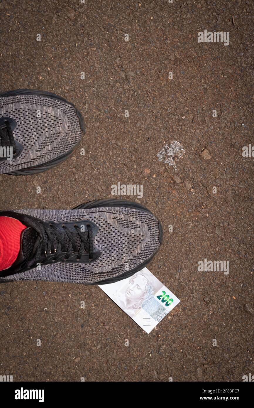 Stepping on Brazilian money. Concept image of Brazilian economy. Stock Photo