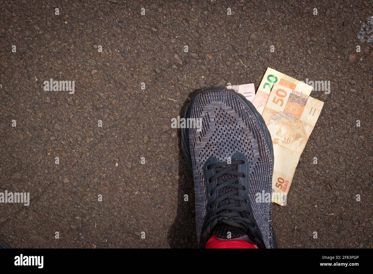 Stepping on Brazilian money. Concept image of Brazilian economy. Stock Photo