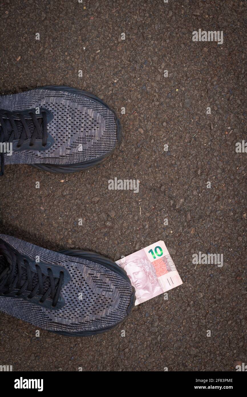 Stepping on Brazilian money. Concept image of Brazilian economy. Stock Photo