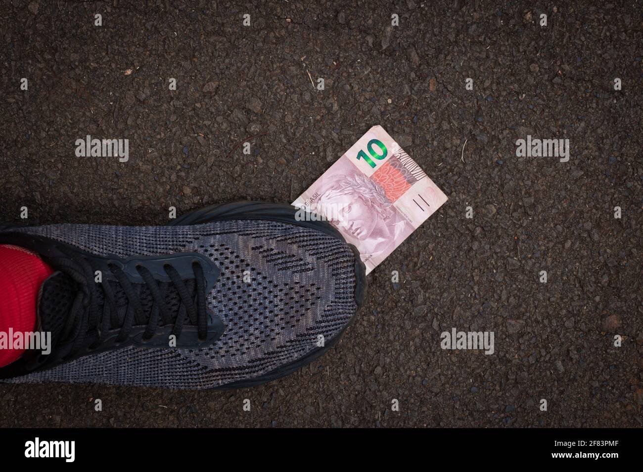 Stepping on Brazilian money. Concept image of Brazilian economy. Stock Photo