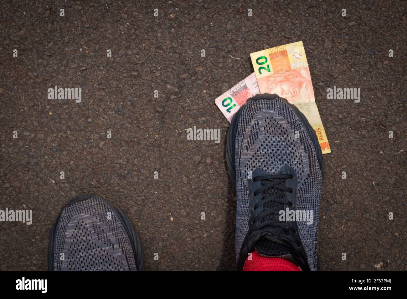 Stepping on Brazilian money. Concept image of Brazilian economy. Stock Photo