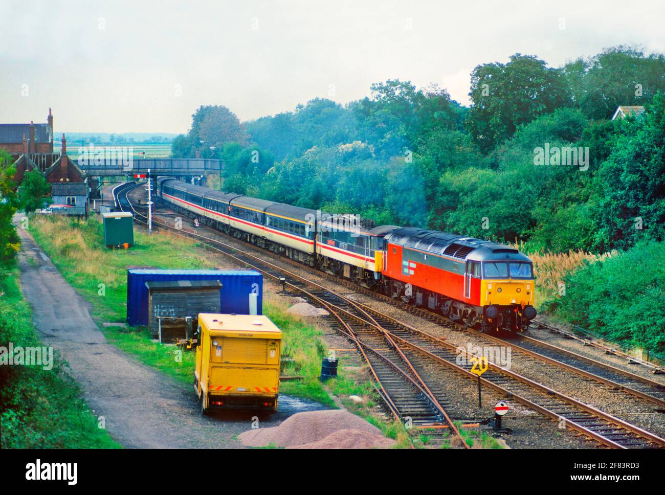 A Class 47 diesel locomotive number 47583 dragging a Class 86 electric locomotive number 86238 and an InterCity service at Reedham on the non electrified Wherry Lines. 18th September 1993. Stock Photo
