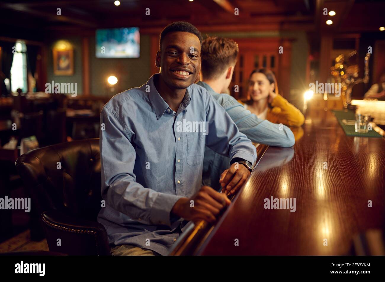 Friends leisures at the counter in bar, nightlife Stock Photo